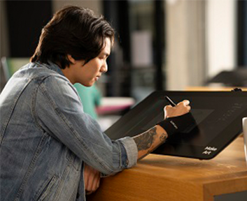 Right-handed person with glove drawing on a Cintiq tablet